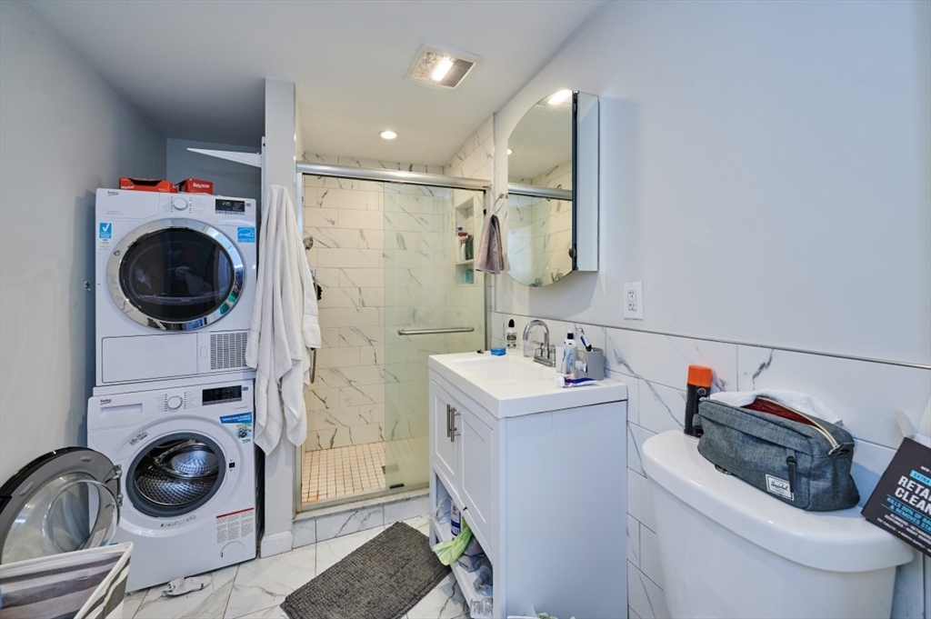 241-243 E Street Boston, MA 02127 - Photo 9 of 16 a bathroom with a sink a washer and dryer