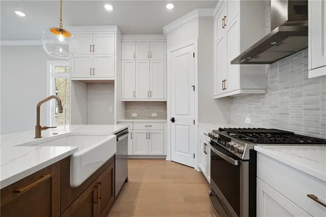 a kitchen with granite countertop a sink stove and cabinets