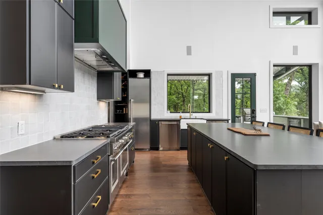 a kitchen with stainless steel appliances a sink stove and cabinets