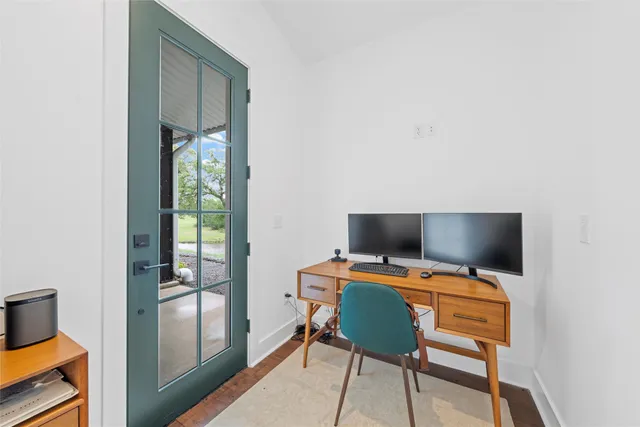 a view of a workspace with furniture and a window