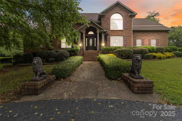 a front view of a house with a yard and potted plants