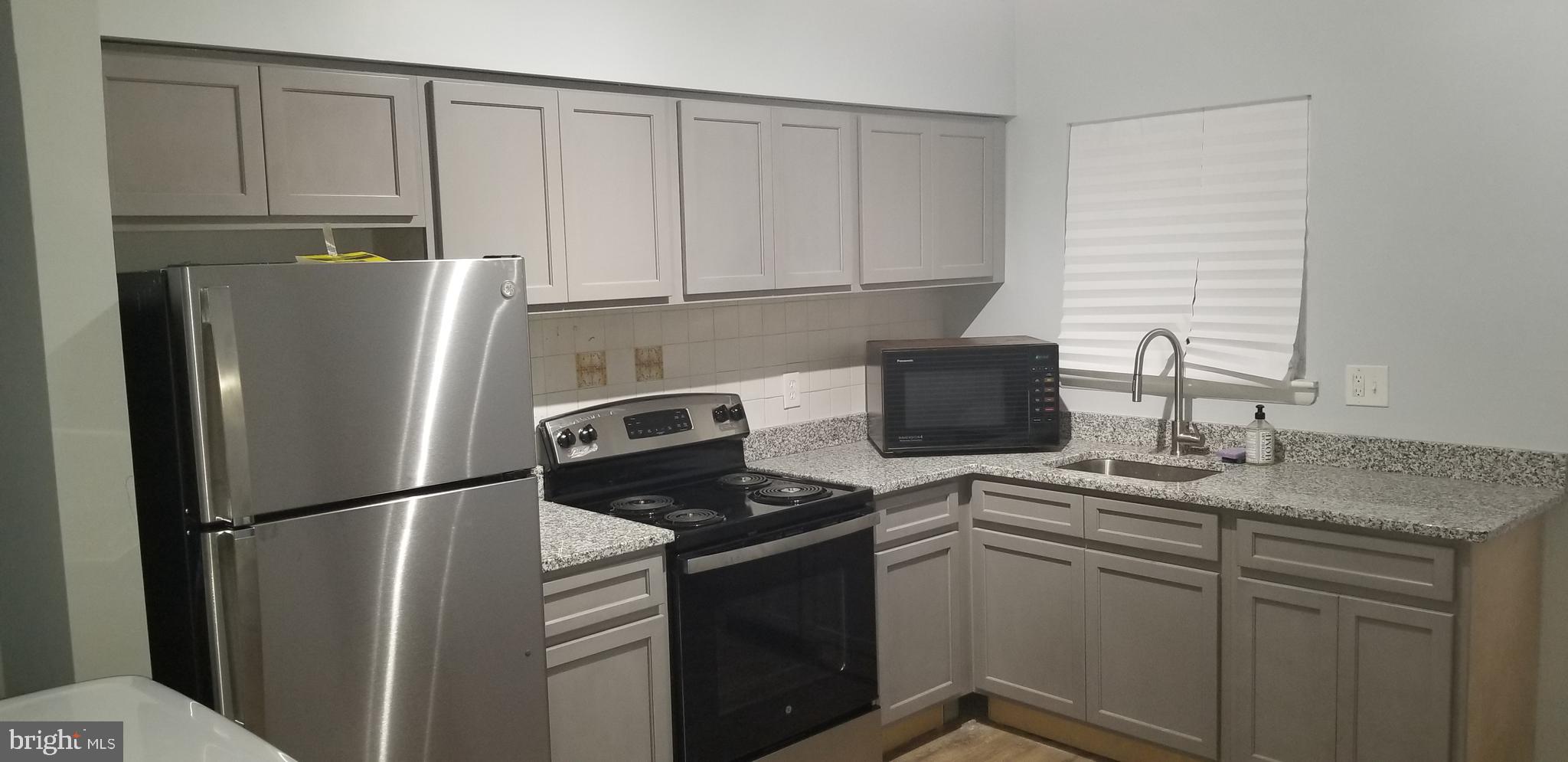 1624 West Lexington Street Baltimore, MD 21223 - Photo 17 of 63 a kitchen with stainless steel appliances granite countertop a refrigerator sink and stove