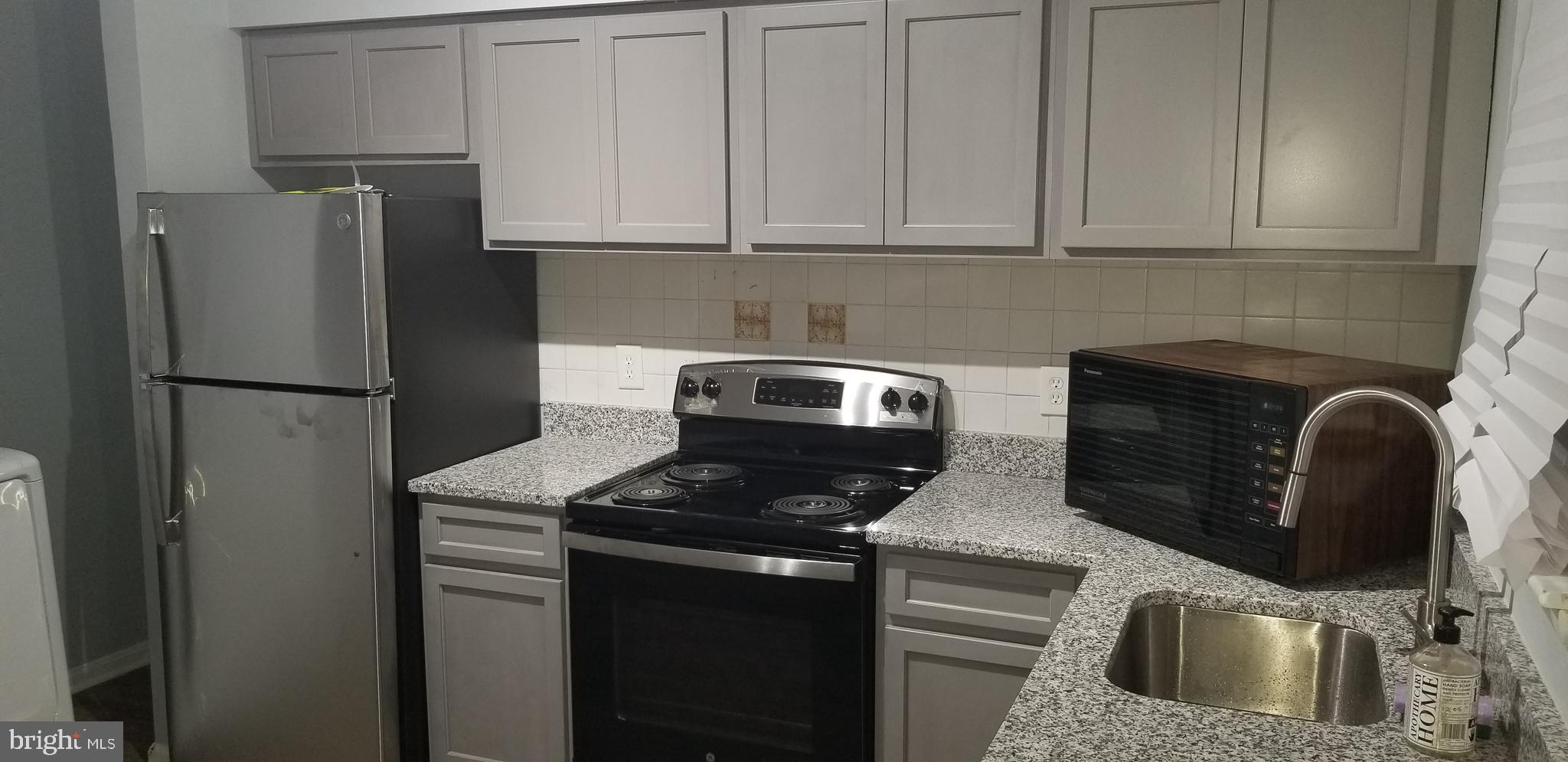 1624 West Lexington Street Baltimore, MD 21223 - Photo 18 of 63 a kitchen with stainless steel appliances granite countertop a refrigerator sink and stove