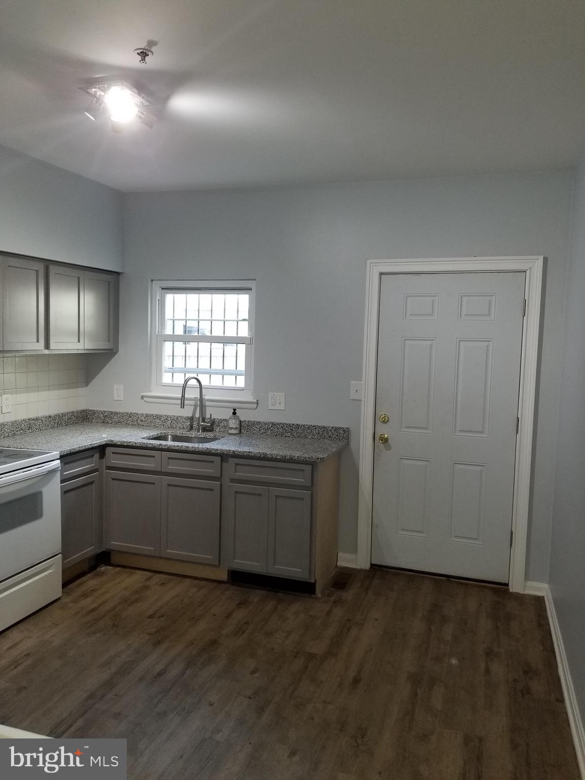 1624 West Lexington Street Baltimore, MD 21223 - Photo 24 of 63 a kitchen with granite countertop cabinets stainless steel appliances a sink and a window