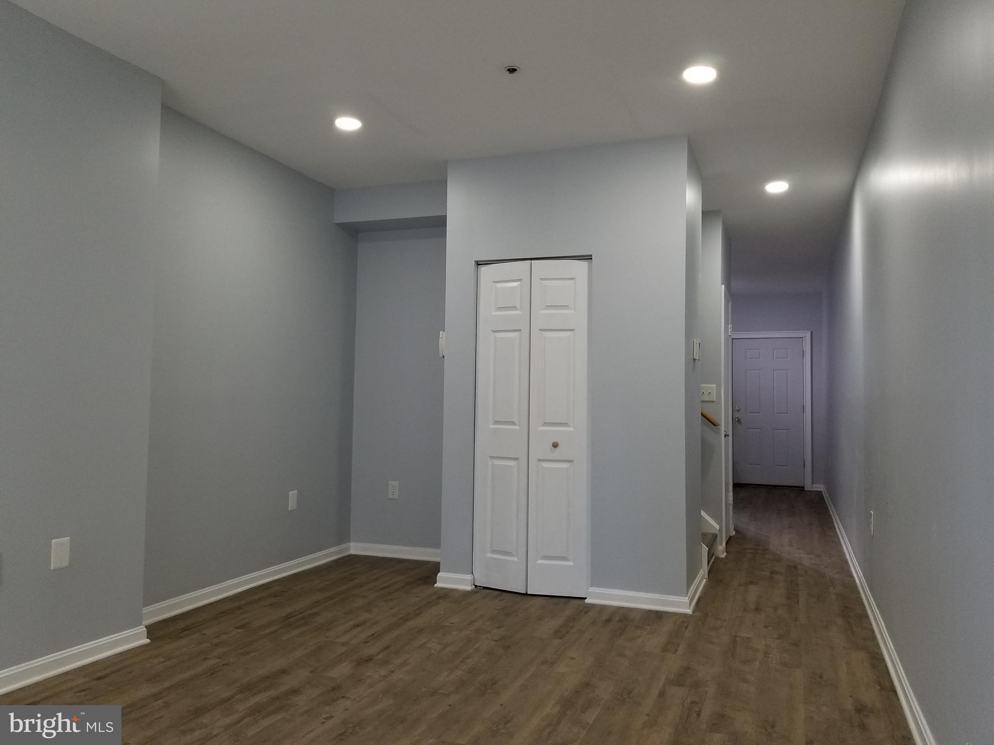 1624 West Lexington Street Baltimore, MD 21223 - Photo 3 of 63 an empty room with wooden floor and sliding door