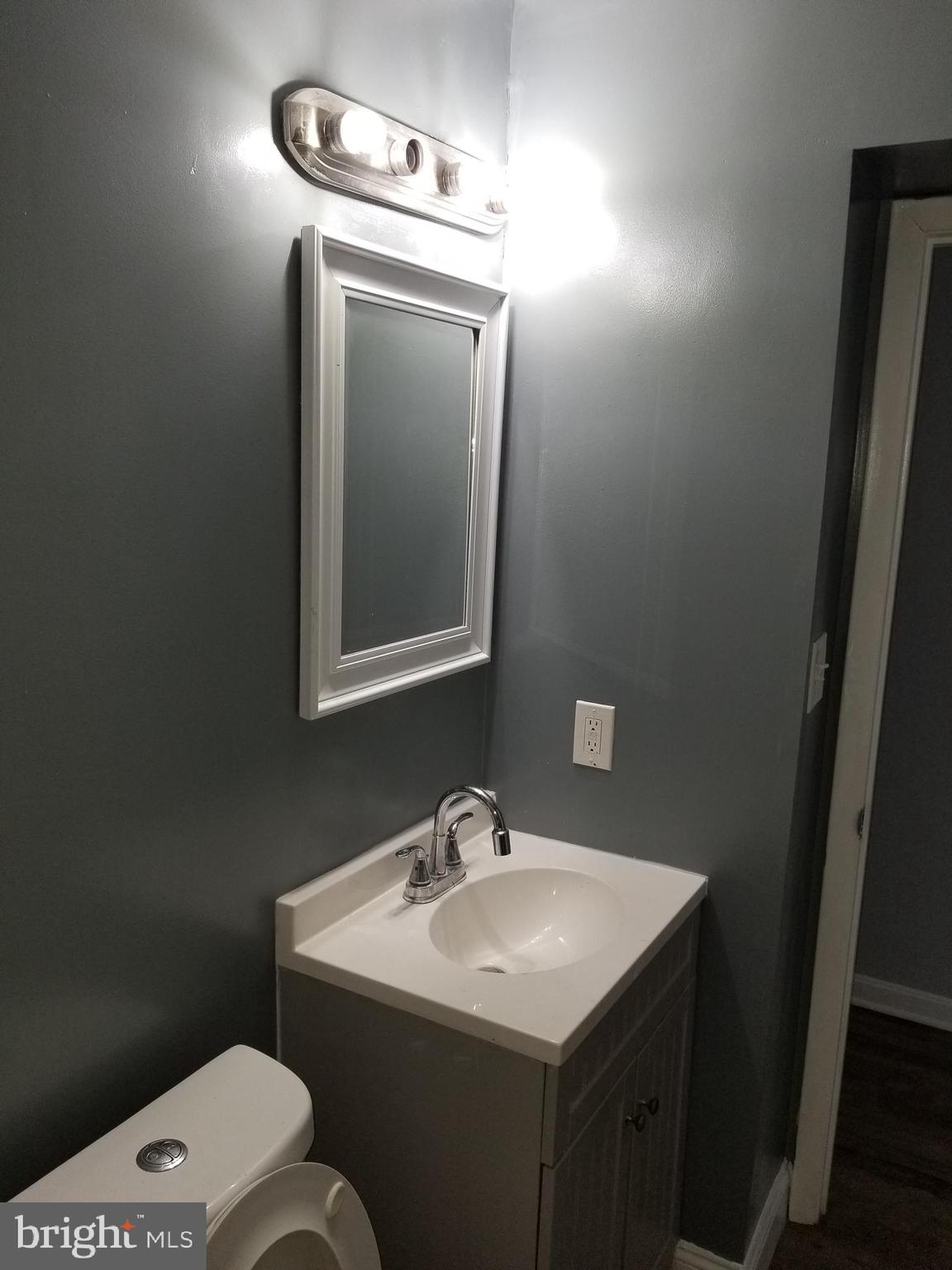 1624 West Lexington Street Baltimore, MD 21223 - Photo 33 of 63 a bathroom with a toilet sink and mirror