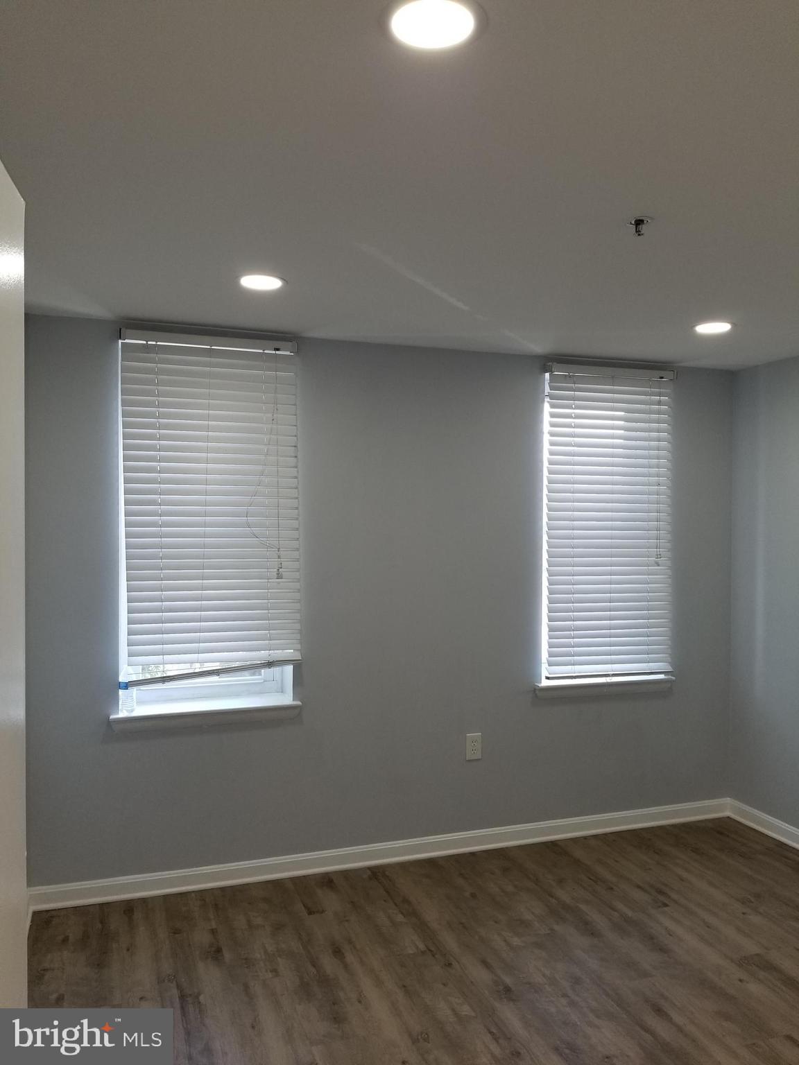 1624 West Lexington Street Baltimore, MD 21223 - Photo 35 of 63 an empty room with wooden floor and windows