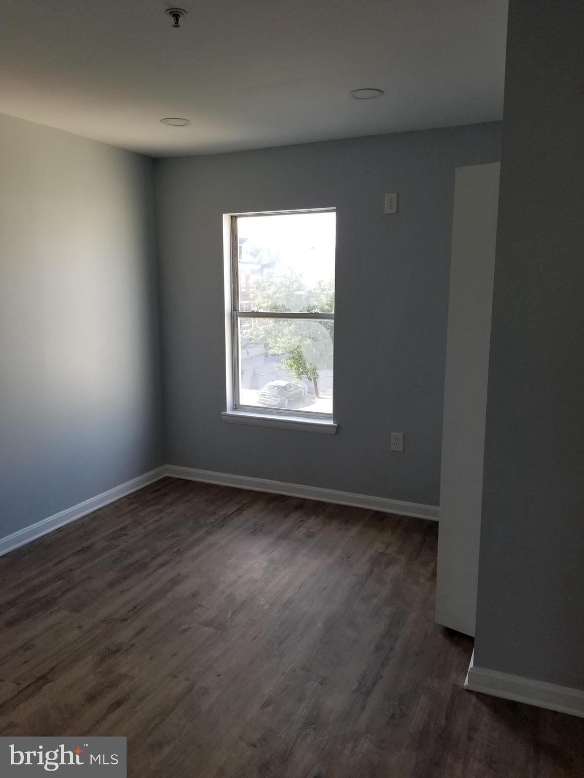 1624 West Lexington Street Baltimore, MD 21223 - Photo 46 of 63 an empty room with wooden floor and windows