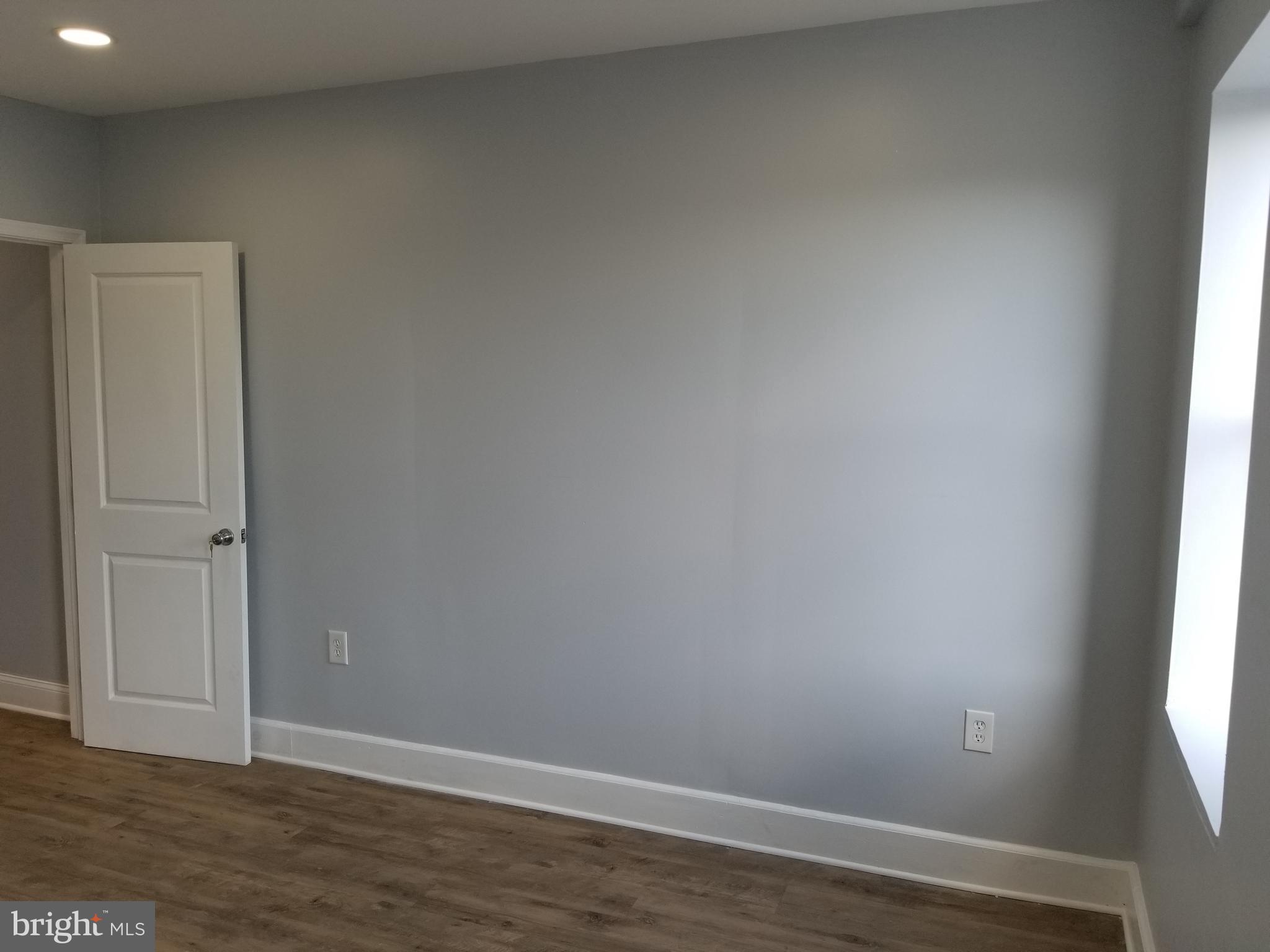 1624 West Lexington Street Baltimore, MD 21223 - Photo 56 of 63 an empty room with wooden floor and windows