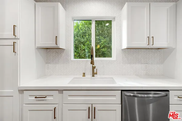 a kitchen with white cabinets and appliances