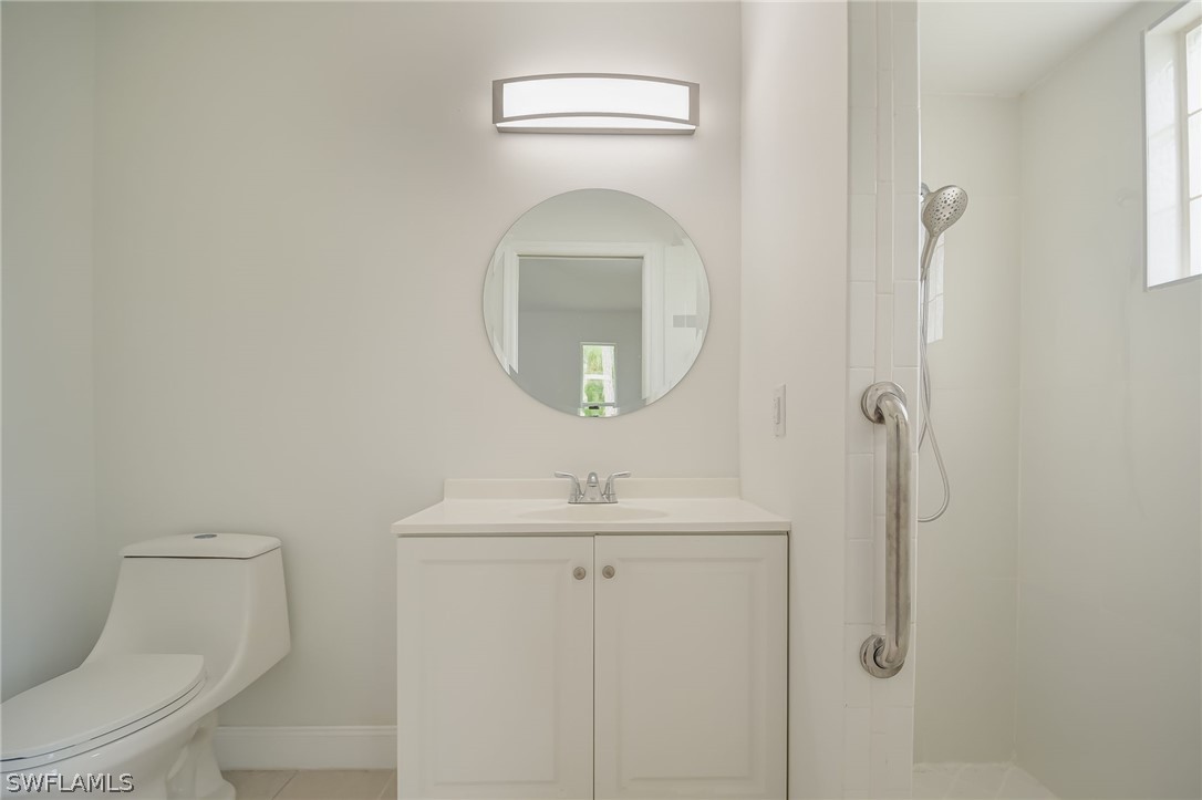 18298 Hepatica Road Fort Myers, FL 33967 - Photo 14 of 25 a bathroom with a toilet sink vanity and mirror