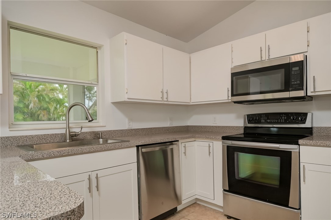 18298 Hepatica Road Fort Myers, FL 33967 - Photo 9 of 25 a kitchen with granite countertop white cabinets appliances and a window