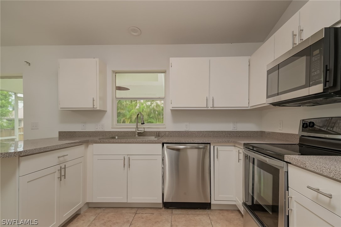 18298 Hepatica Road Fort Myers, FL 33967 - Photo 10 of 25 a kitchen with white cabinets appliances and a window