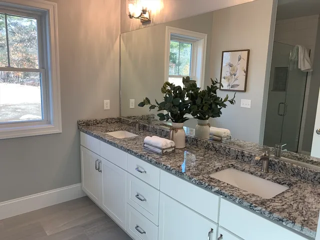 a bathroom with a granite countertop sink and a mirror