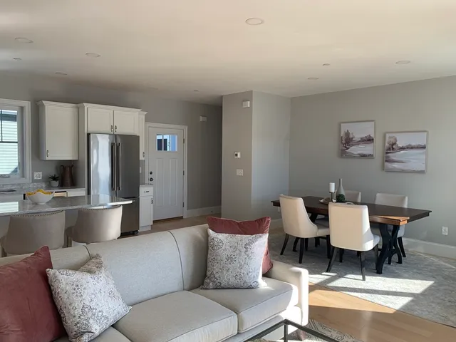 a living room with furniture and a refrigerator