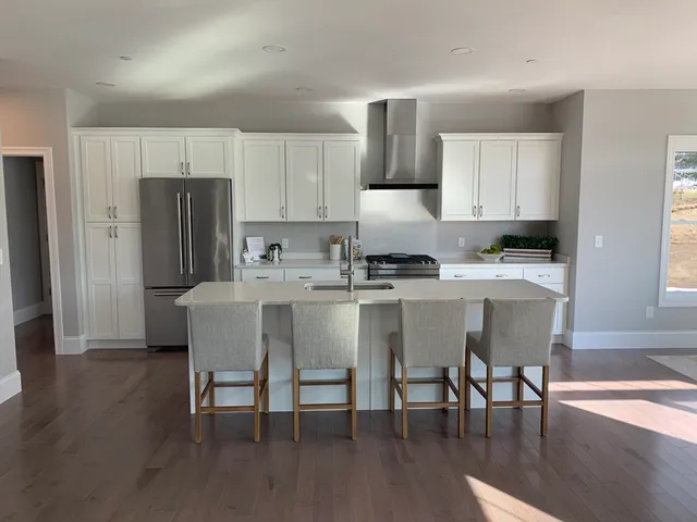 a kitchen with a table chairs refrigerator and microwave