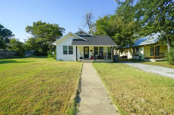 a front view of a house with a yard and trees