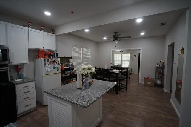 a kitchen with refrigerator and chairs