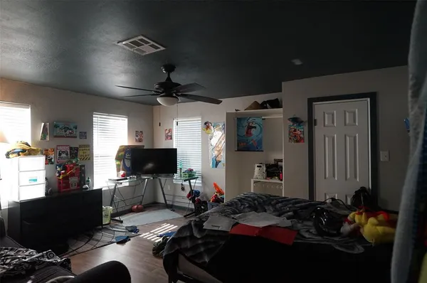 a bedroom with furniture and a flat screen tv