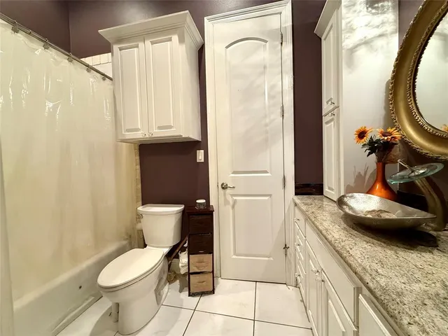 a bathroom with a granite countertop toilet sink and mirror