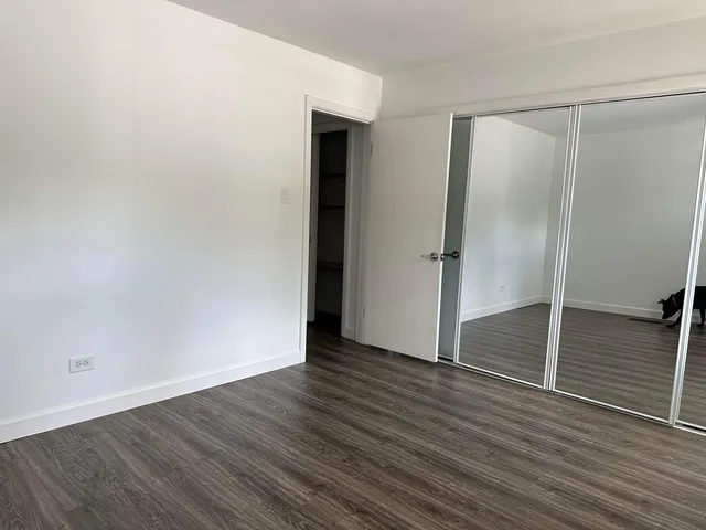 an empty room with wooden floor and closet