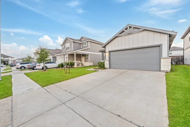 a view of a white house with a yard and plants