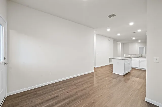 a view of a kitchen with wooden floor and windows