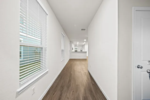 a view of a hallway with wooden floor and staircase