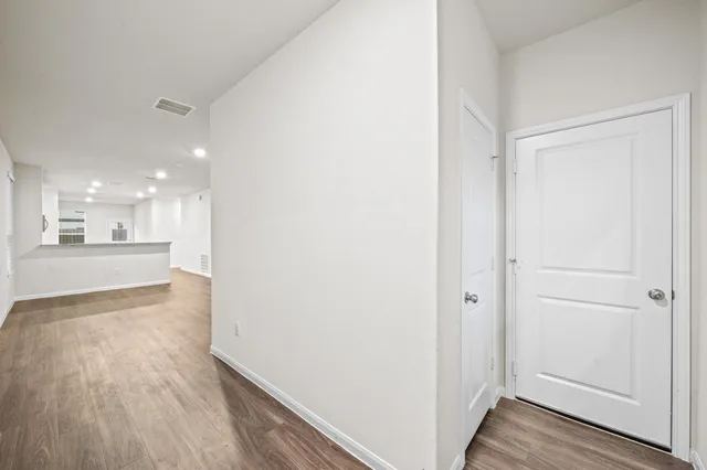 a view of a hallway with wooden floor