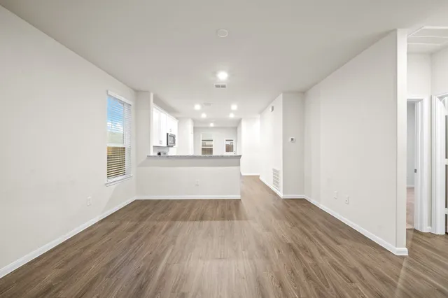 a view of a kitchen with wooden floor and a window