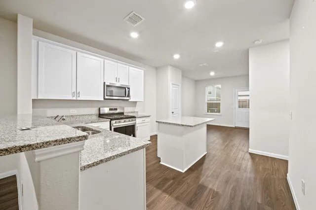 a kitchen with granite countertop white cabinets and white appliances