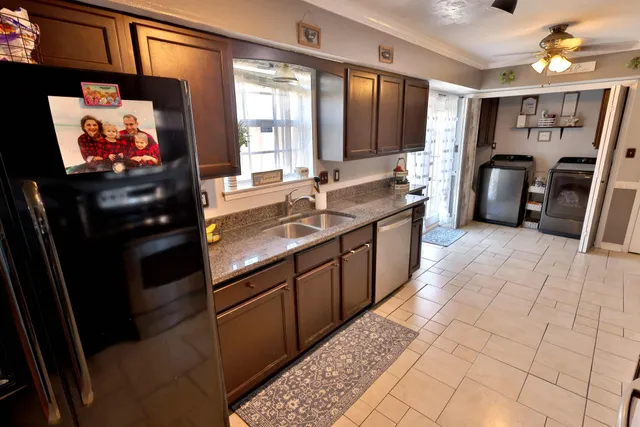 a kitchen with stainless steel appliances granite countertop a refrigerator and a sink