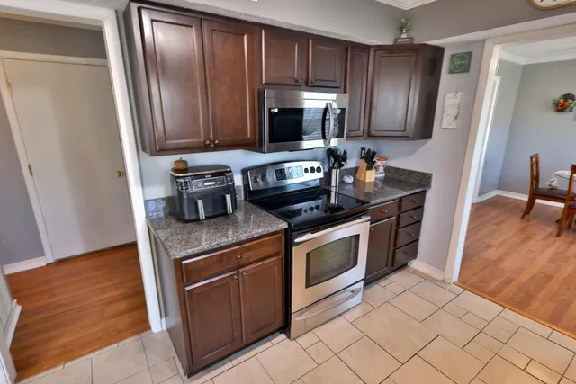 a kitchen with stainless steel appliances granite countertop a stove a microwave and a refrigerator