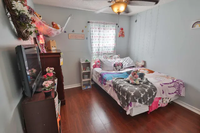 a bedroom with a bed and wooden floor