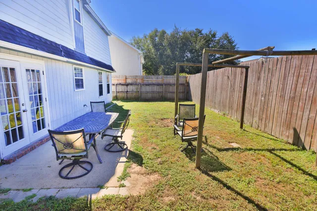 a balcony with chairs and a potted plant