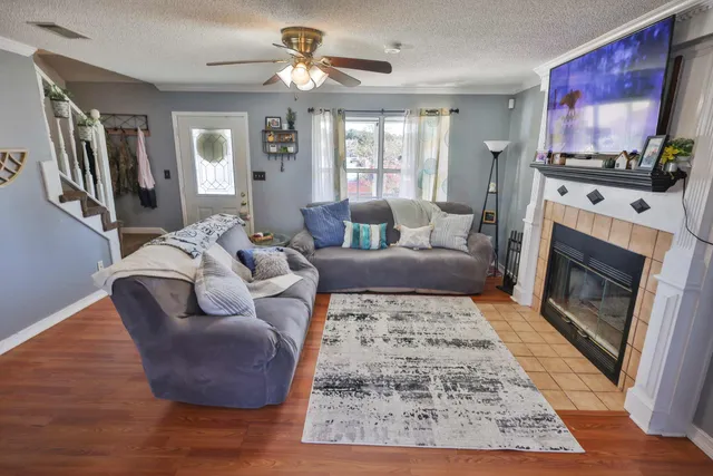 a living room with furniture a flat screen tv and a fireplace