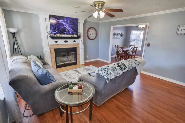 a living room with furniture a fireplace and wooden floor