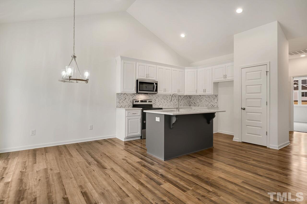 4066 Needham Road Bailey, NC 27807 - Photo 11 of 25 a kitchen with stainless steel appliances granite countertop a stove a sink and a refrigerator with wooden floor