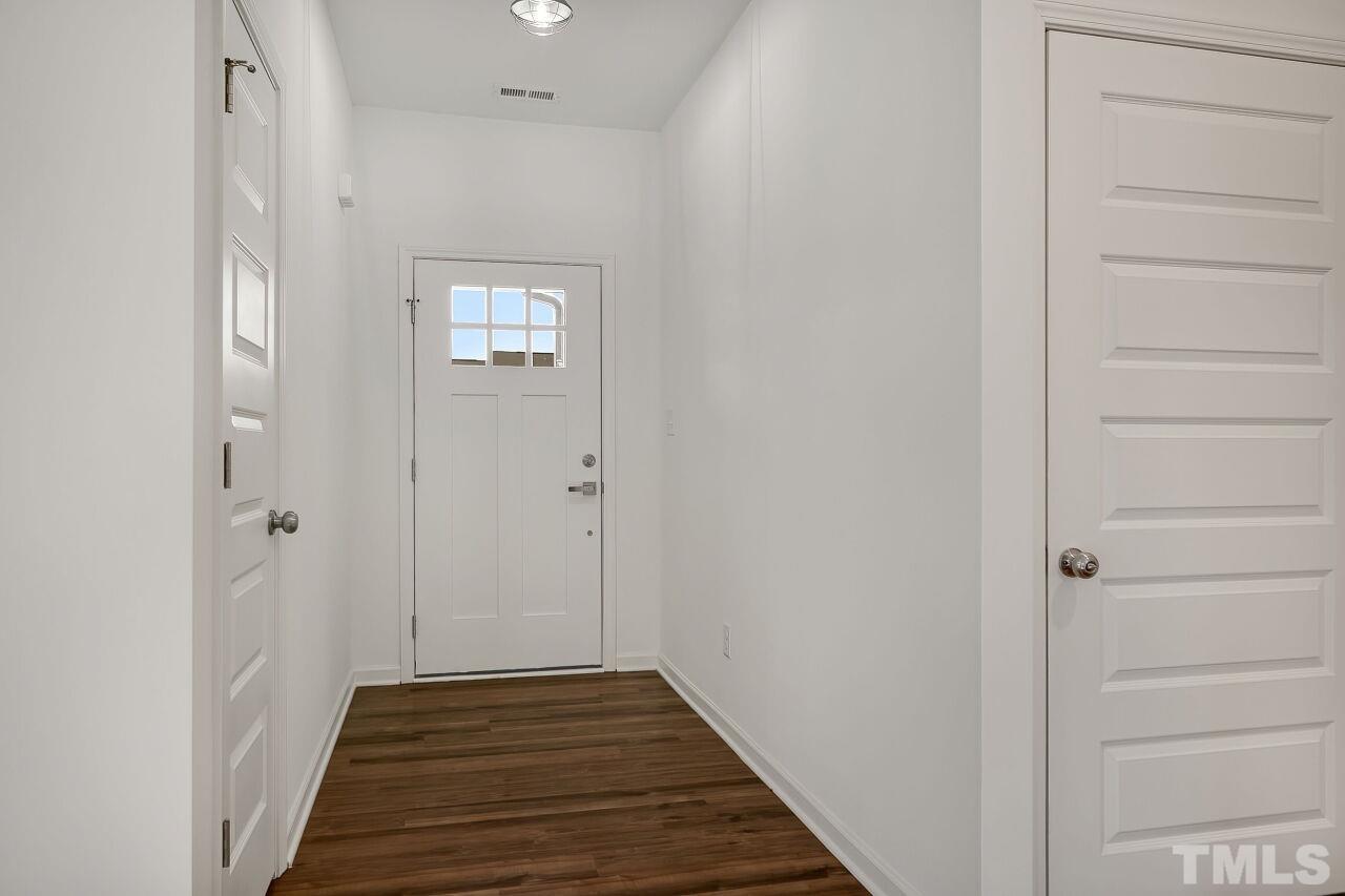 4066 Needham Road Bailey, NC 27807 - Photo 6 of 25 a view of a hallway with wooden floor and a bathroom