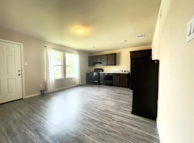 a view of a kitchen with wooden floor and electronic appliances