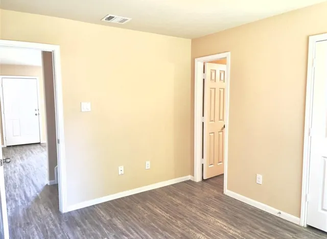 a view of a room with wooden floor and a bathroom