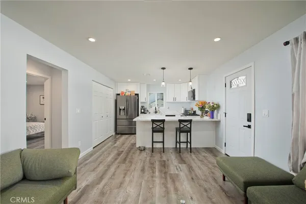 a living room with kitchen island furniture and a flat screen tv