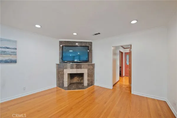 a view of empty room with fireplace and wooden floor
