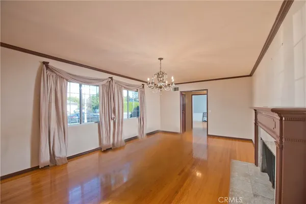a view of a room that has wooden floor and windows