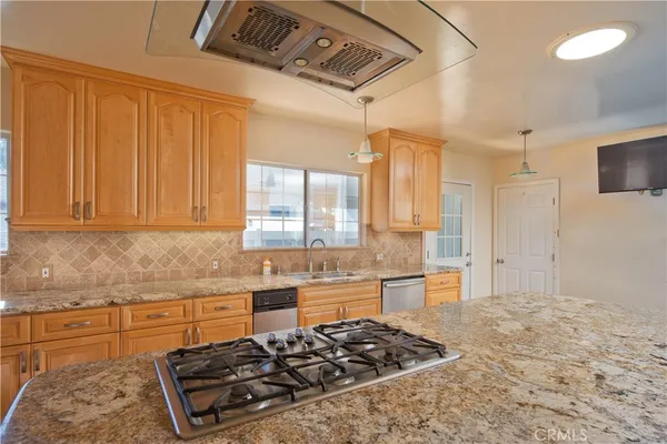 a kitchen with stainless steel appliances granite countertop a sink and a stove