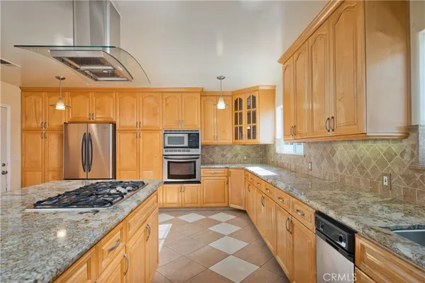 a kitchen with stainless steel appliances granite countertop a stove a sink and a refrigerator