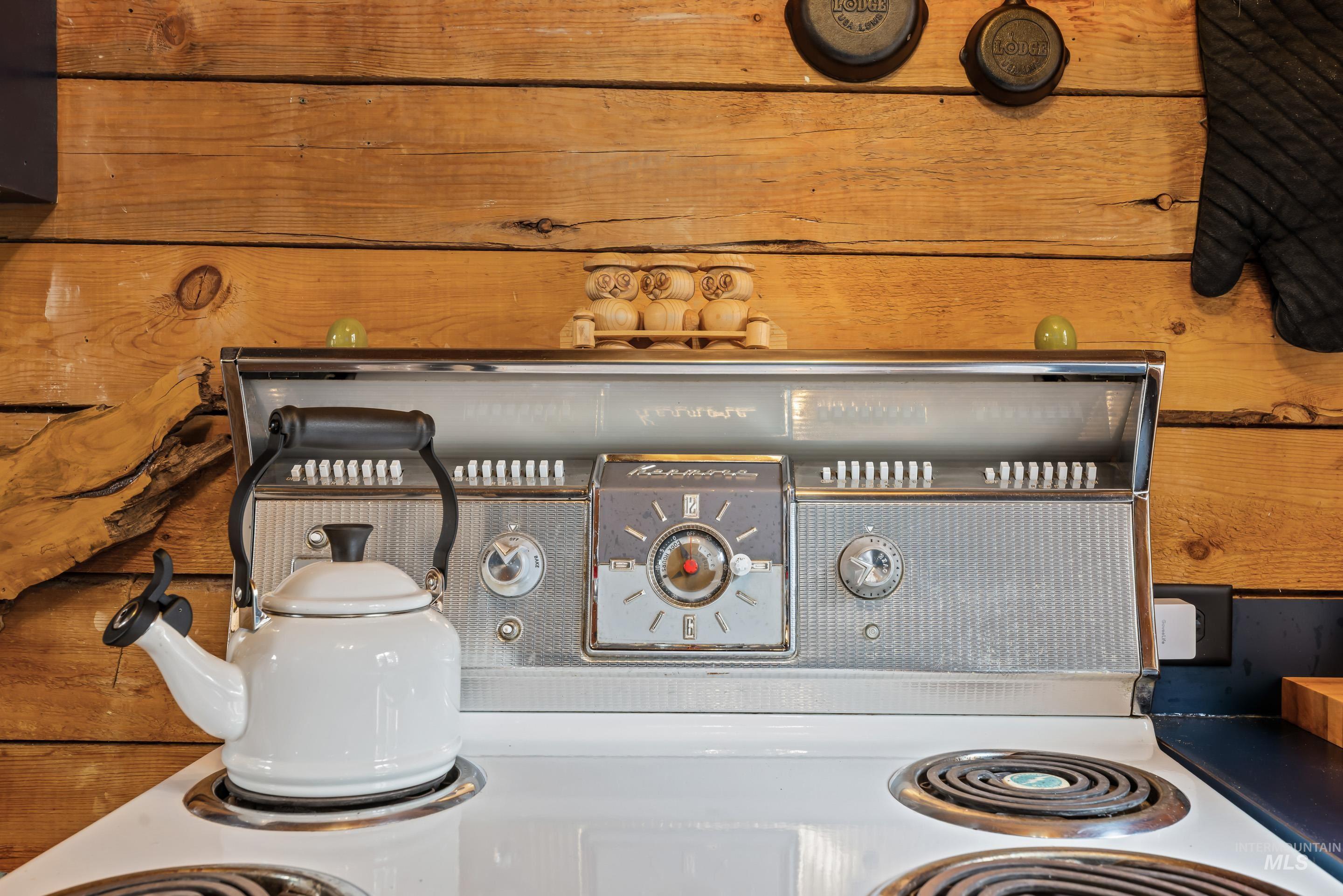 73 Rainbow Ridge Road Garden Valley, ID 83622 - Photo 12 of 49 White electric range with four coil burners and a retro-style chrome backsplash featuring an integrated clock