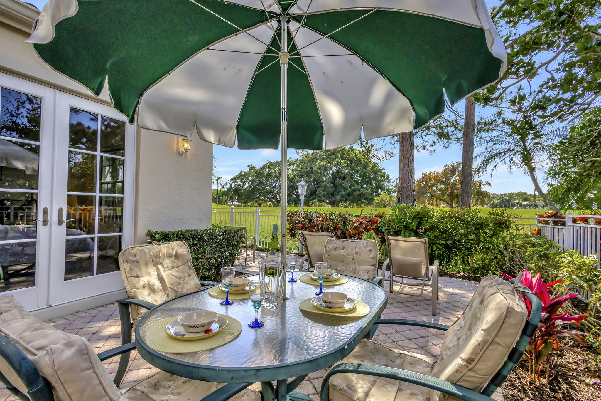 a view of a patio with a dining table and chairs under an umbrella