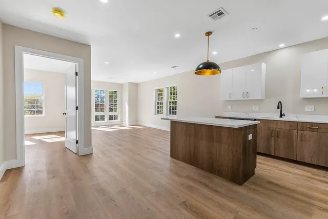 a kitchen with wooden floors and wide window