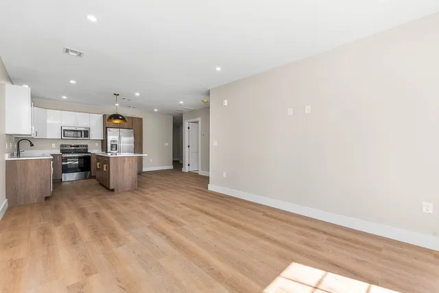 a view of kitchen with stainless steel appliances refrigerator stove microwave and cabinets